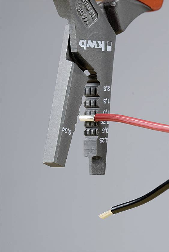Eine Zange hält ein rotes isoliertes Kabel und entfernt die Isolierung, um den blanken Draht freizulegen. Ein schwarzes Kabel ist teilweise zu sehen.