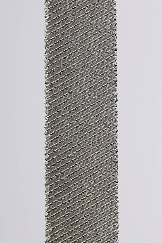 Eine Nahaufnahme einer Metallfeile mit diagonalen Rillen auf einer grauen Fläche.