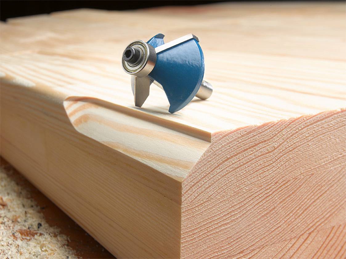 Fräser für Holzbearbeitung liegt auf geformtem Holzstück, zeigt präzise Schnittmuster durch den Einsatz des Werkzeugs.