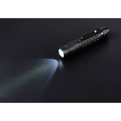 Schwarze Taschenlampe strahlt helles Licht auf dunkle Oberfläche.