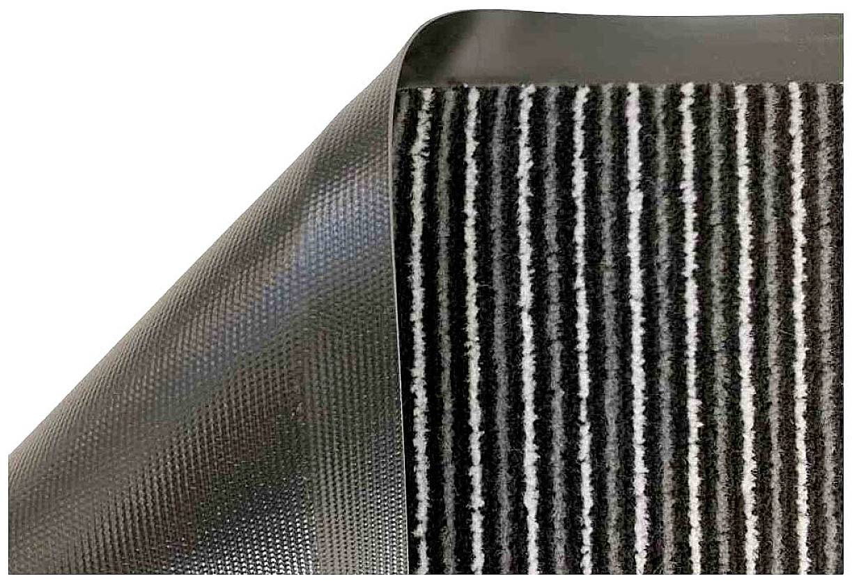 Ein rechteckiger Teppich mit einem gestreiften Muster in Schwarz, Weiß und Grau; die Ecke ist nach oben geklappt und zeigt die rutschfeste Unterseite.
