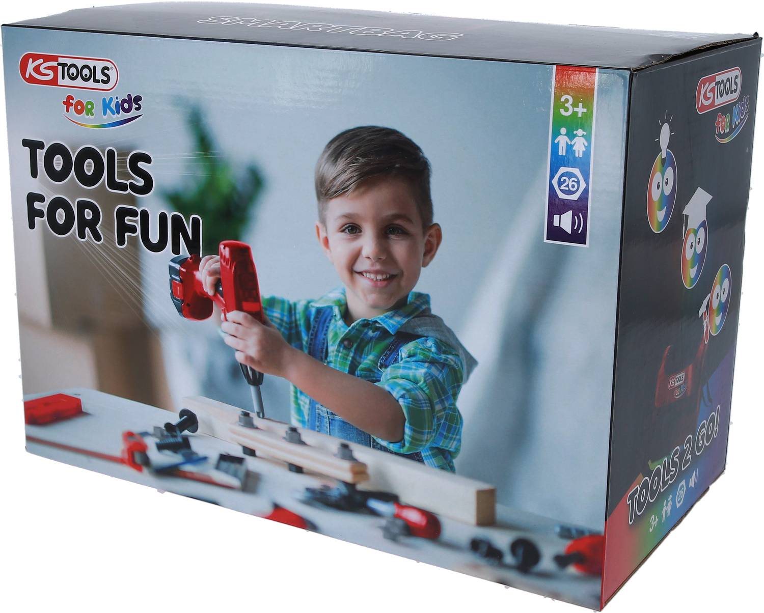 Ein Junge in kariertem Hemd spielt mit einem roten Spielzeug-Bohrer an einem Holzbrett. Verpackung zeigt Kinder-Werkzeugset.