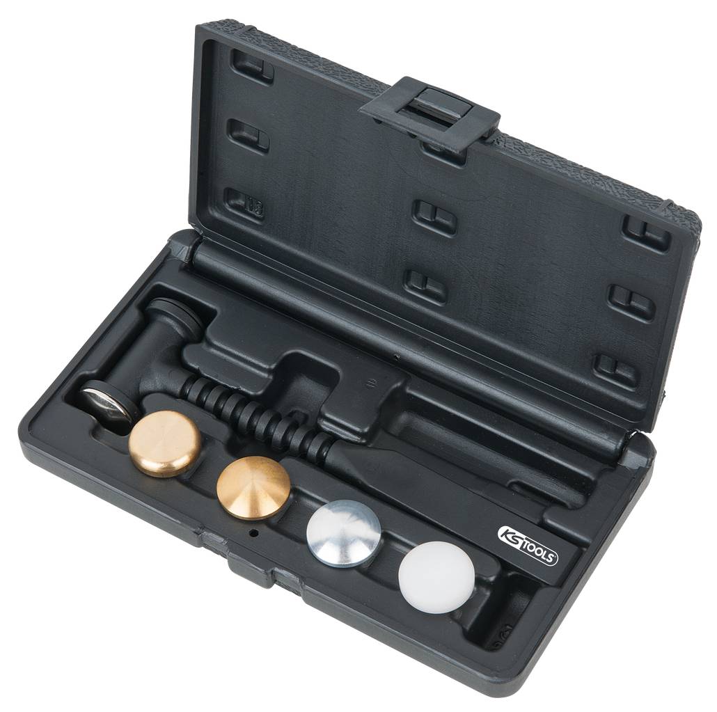 Ein Werkzeugsatz in einer offenen schwarzen Box; enthält einen Hammer und vier austauschbare Köpfe in verschiedenen Materialien.