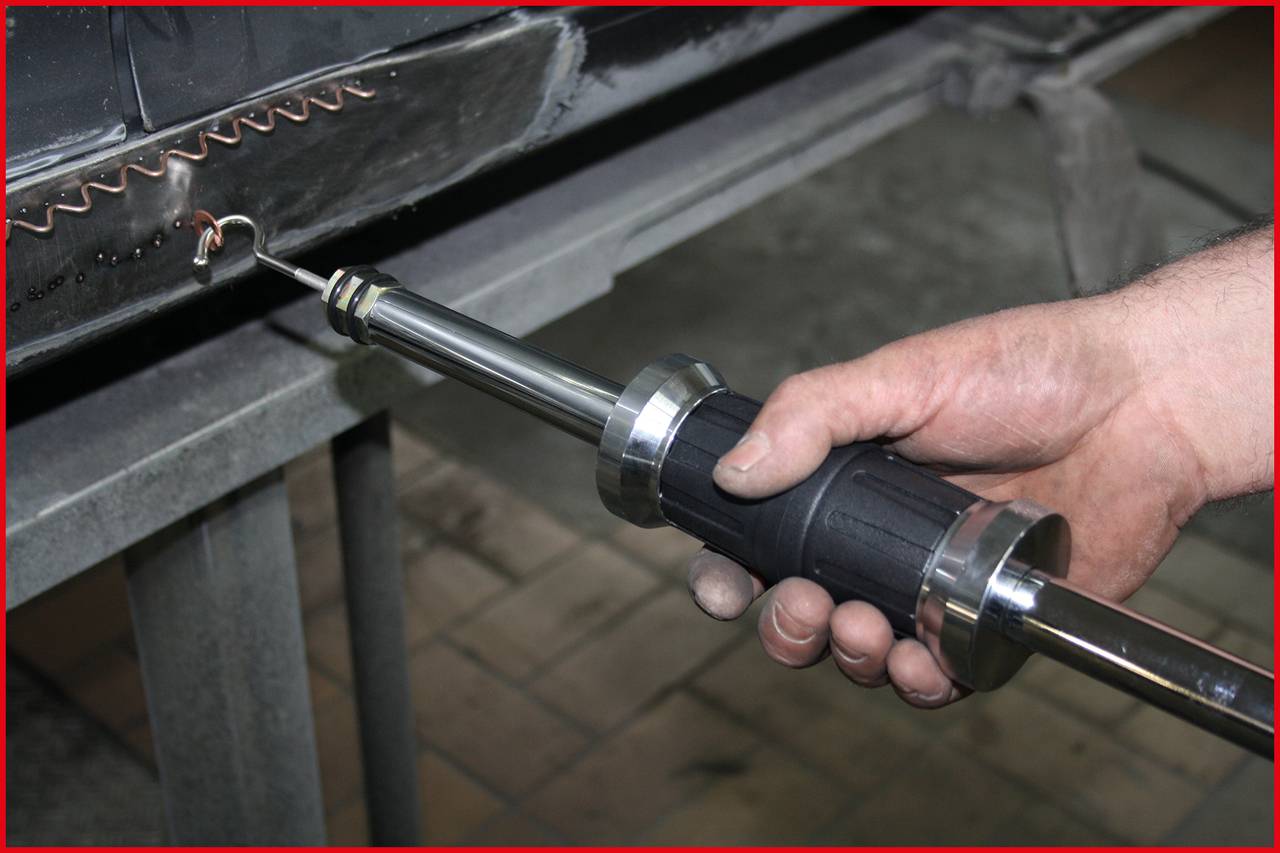 'Person verwendet ein Werkzeugs zum Spot-Schweißen auf Metalloberfläche in einer Werkstatt.'