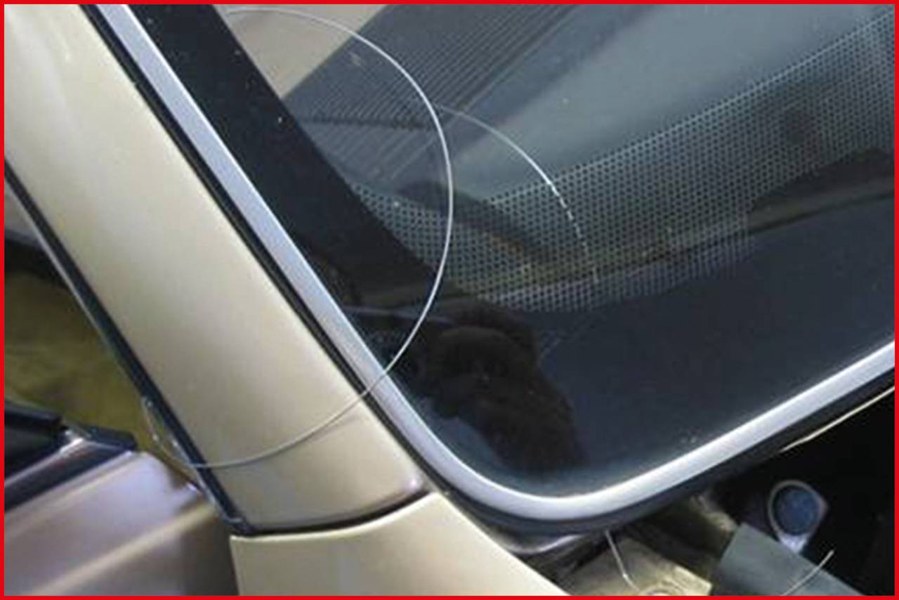 Ein Auto mit einem kleinen Riss in der Windschutzscheibe in der unteren rechten Ecke nahe der Karosserie.