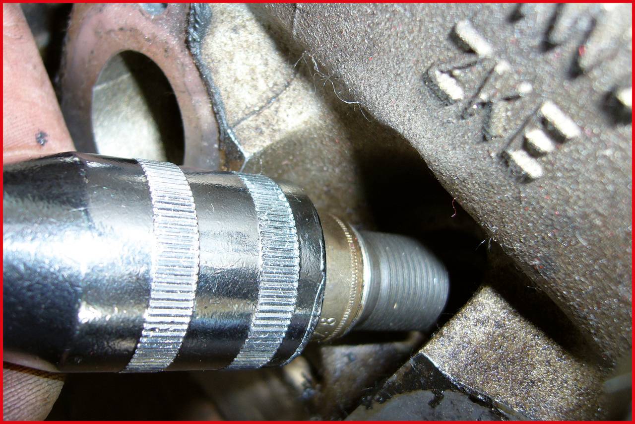 Nahaufnahme eines Metallrohrs, das an ein Gewinde einer maschinellen Komponente angeschlossen wird. Es zeigt Details der Metallstruktur.