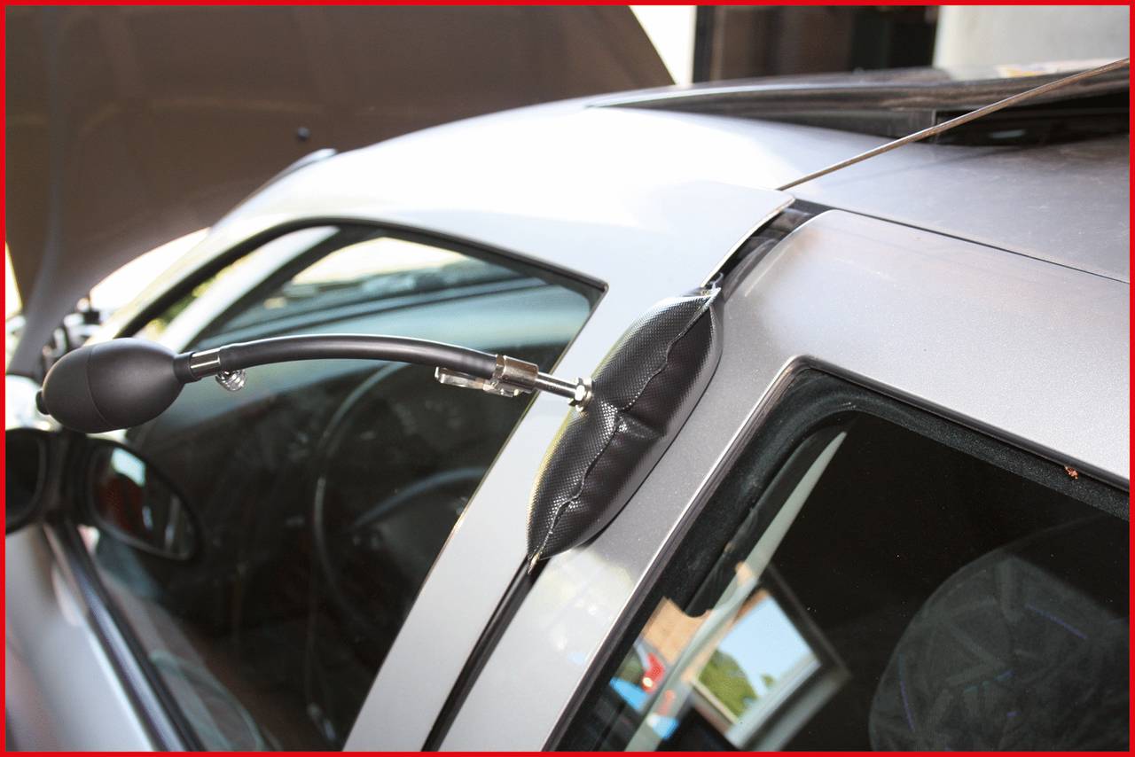 Ein Autotür wird mit einem Autotür-Öffner-Werkzeug geöffnet. Ein aufblasbares Kissen ist zwischen der Tür und dem Rahmen eingesetzt.
