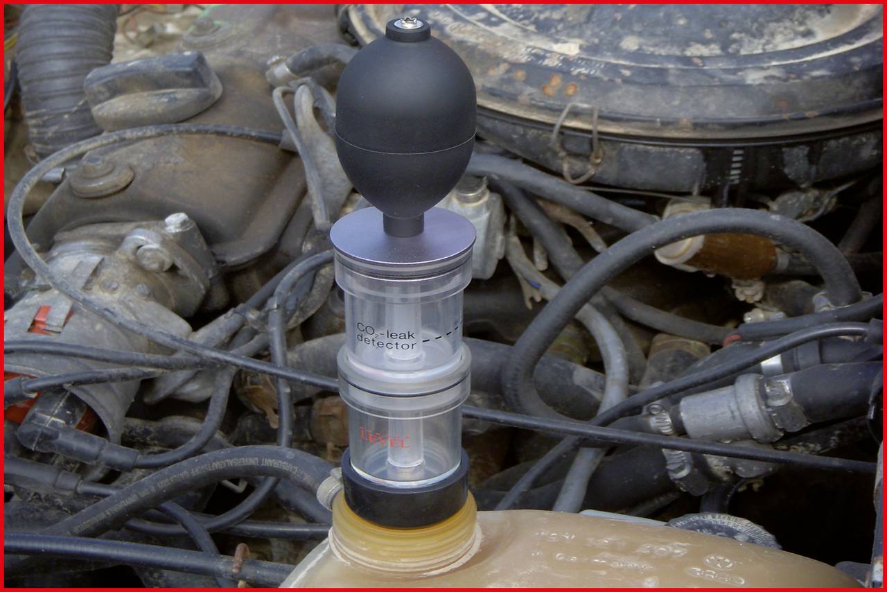 Ein Leckdetektor mit schwarzem Pumpball auf einem Motor zeigt ein mögliches Problem mit einem Fahrzeug.