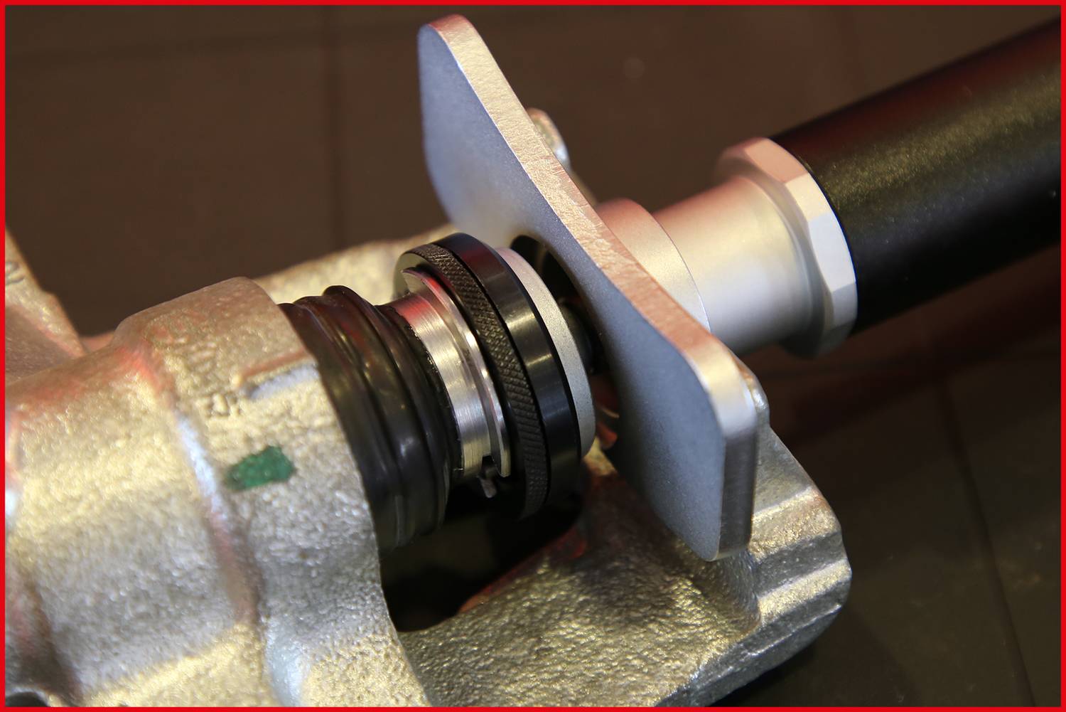 Nahaufnahme eines mechanischen Teils mit beweglichen Komponenten, einschließlich eines Metallzahnrads und einer Kolbenstange.
