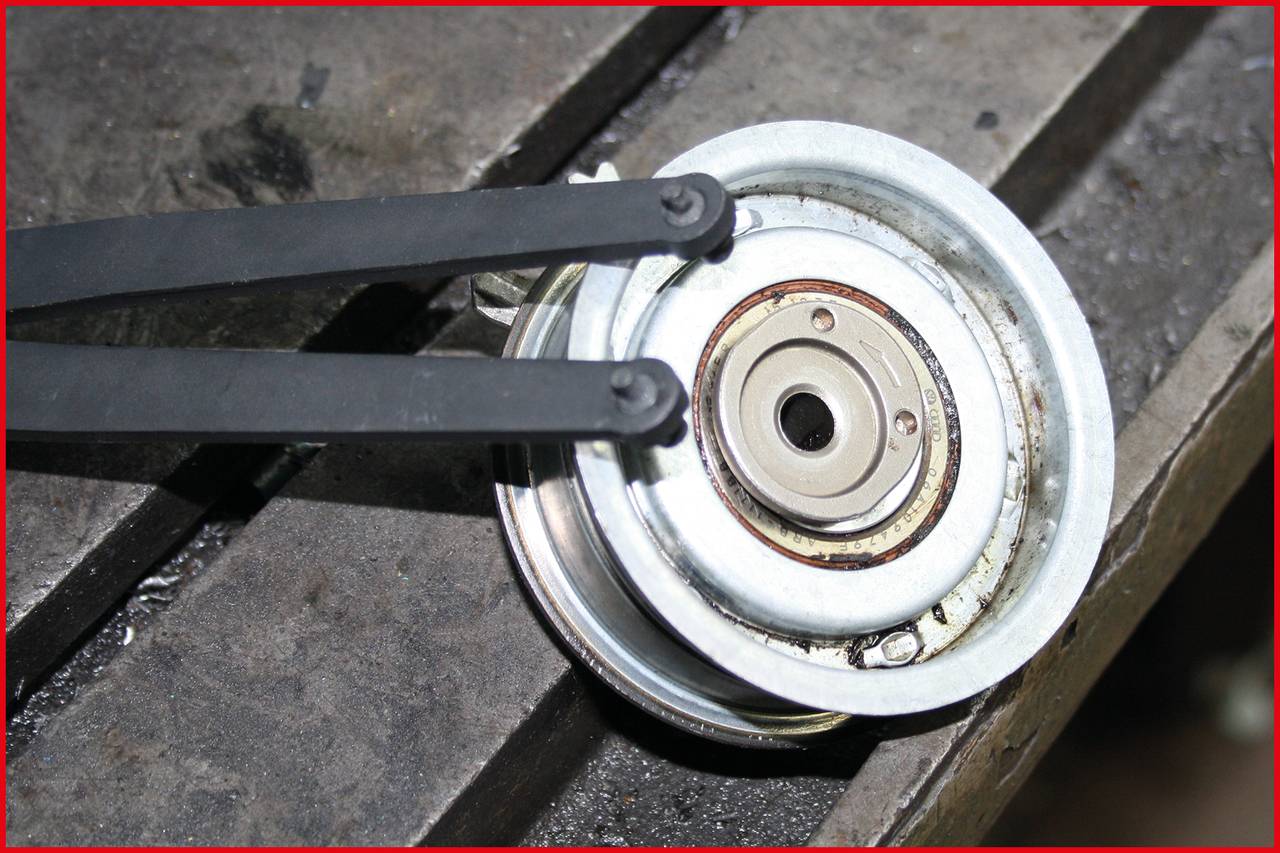 Metallwerkstück liegt auf Werkbank, eingeklemmt von zwei schwarzen Zangen.