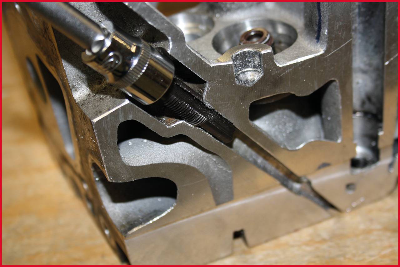 Ein Metallwerkzeug, das in einem Motorteil eingesetzt wird. Es zeigt eine Nahaufnahme des Bearbeitungsprozesses bei einem Metallblock.