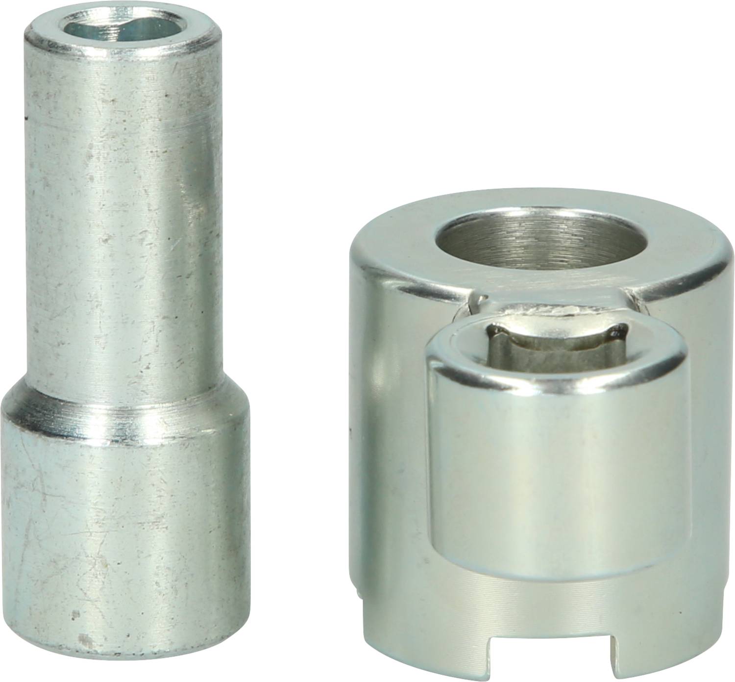 Zwei silberne Metallteile, zylindrisch und kreisförmig, nebeneinander aufgestellt.