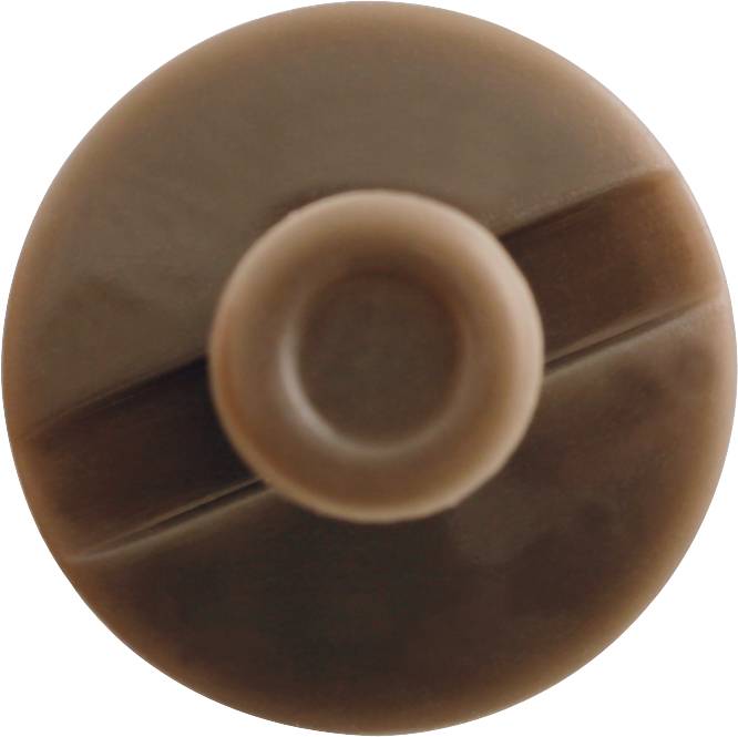 Ein brauner, runder Deckel mit zentraler Erhebung und horizontaler Rille, vermutlich von einer Flasche oder einem Behälter.