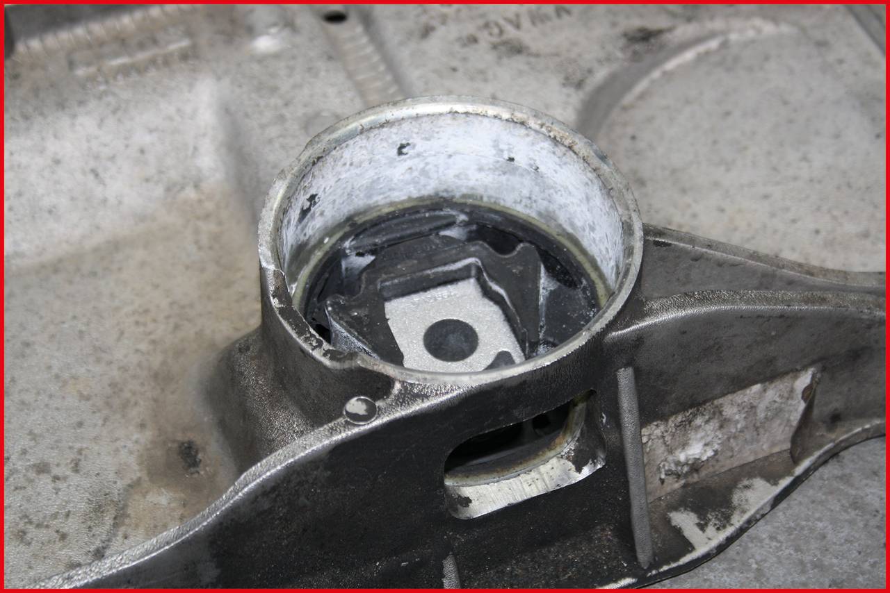 Nahaufnahme eines Metalllagers auf einer grauen, abgenutzten Oberfläche. Das zylindrische Lager hat Spuren von Abnutzung und Schmutz.