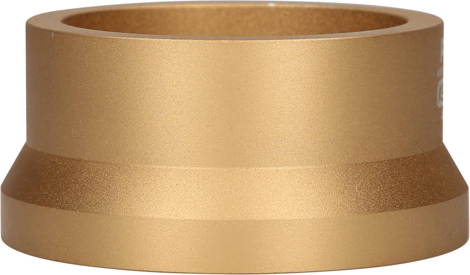 Ein goldfarbener, zylindrischer Metallring mit abgeschrägtem Rand, auf einer weißen Oberfläche stehend.
