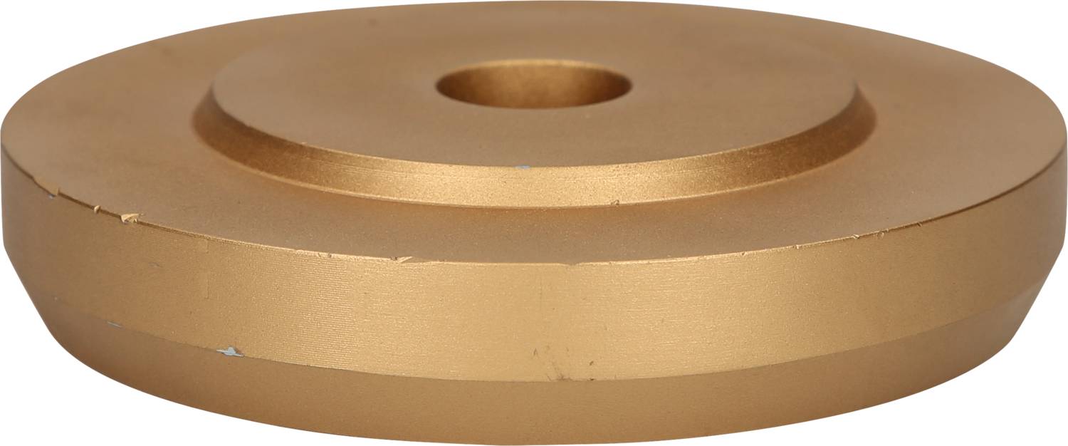 Goldene, zylinderförmige Metallscheibe mit zentraler Vertiefung, auf weißem Hintergrund.