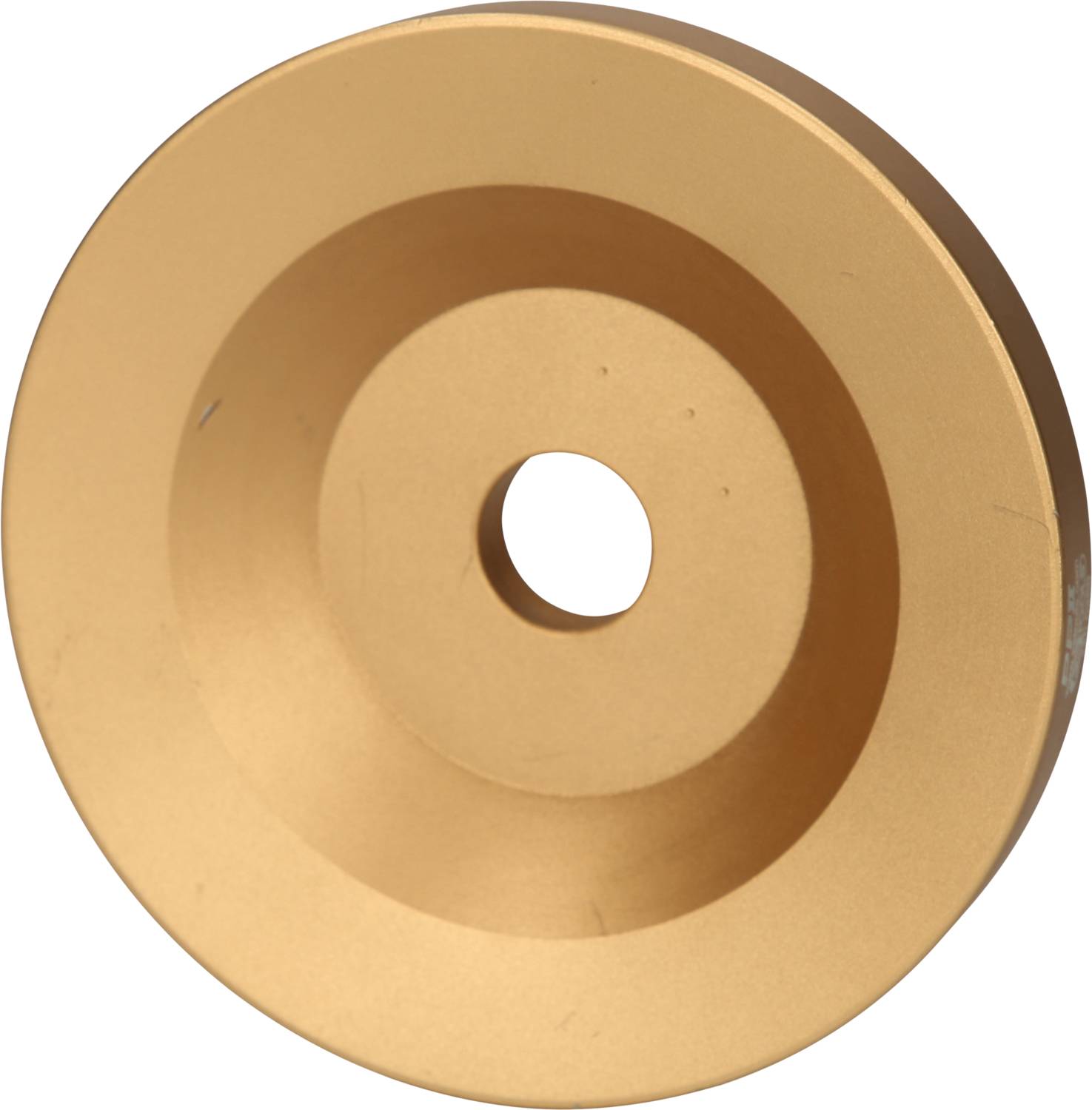 Ein kreisförmiges, goldenes Metallobjekt mit einem Loch in der Mitte, möglicherweise ein Teil eines größeren Mechanismus oder Werkzeugs.