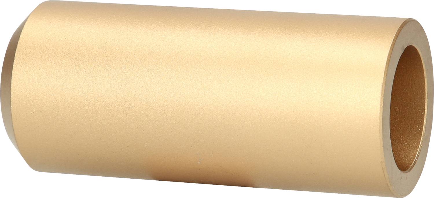 Ein zylindrisches, goldenes Metallstück mit glatter Oberfläche und einem Loch in der Mitte, liegend auf einer weißen Fläche.