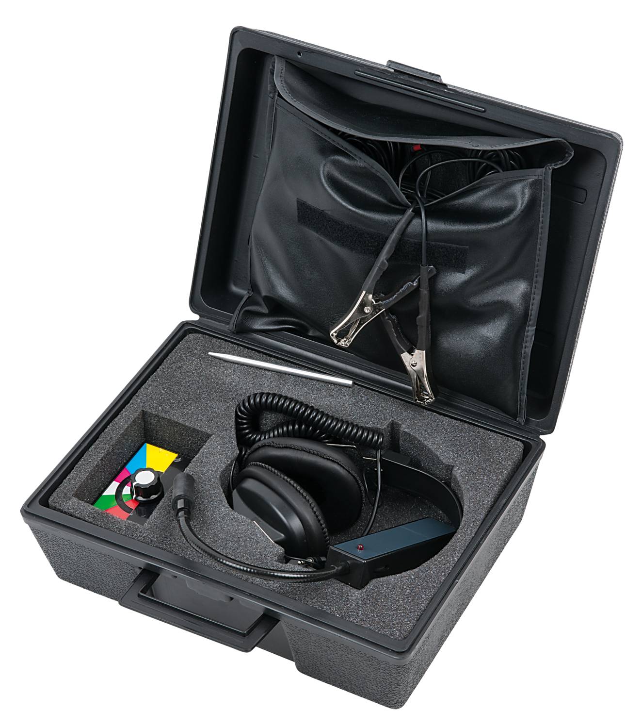 Ein offener schwarzer Koffer enthält Kopfhörer mit Kabel und zwei Klemmen. Im Inneren befinden sich farbige Blöcke und ein Gerät.