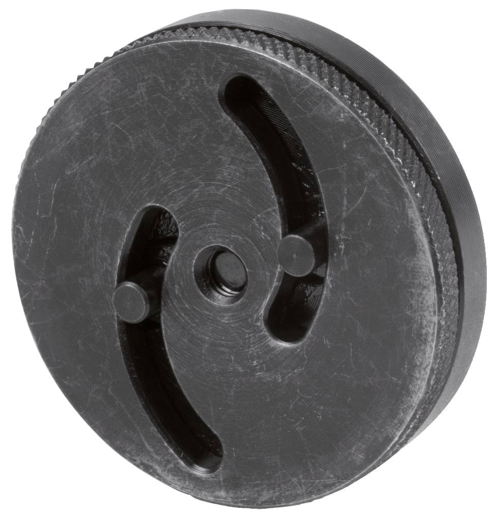Eine runde, schwarze Metallplatte mit zwei geschwungenen Schlitzen und zentralem Loch, möglicherweise ein Teil eines Maschinenelements.