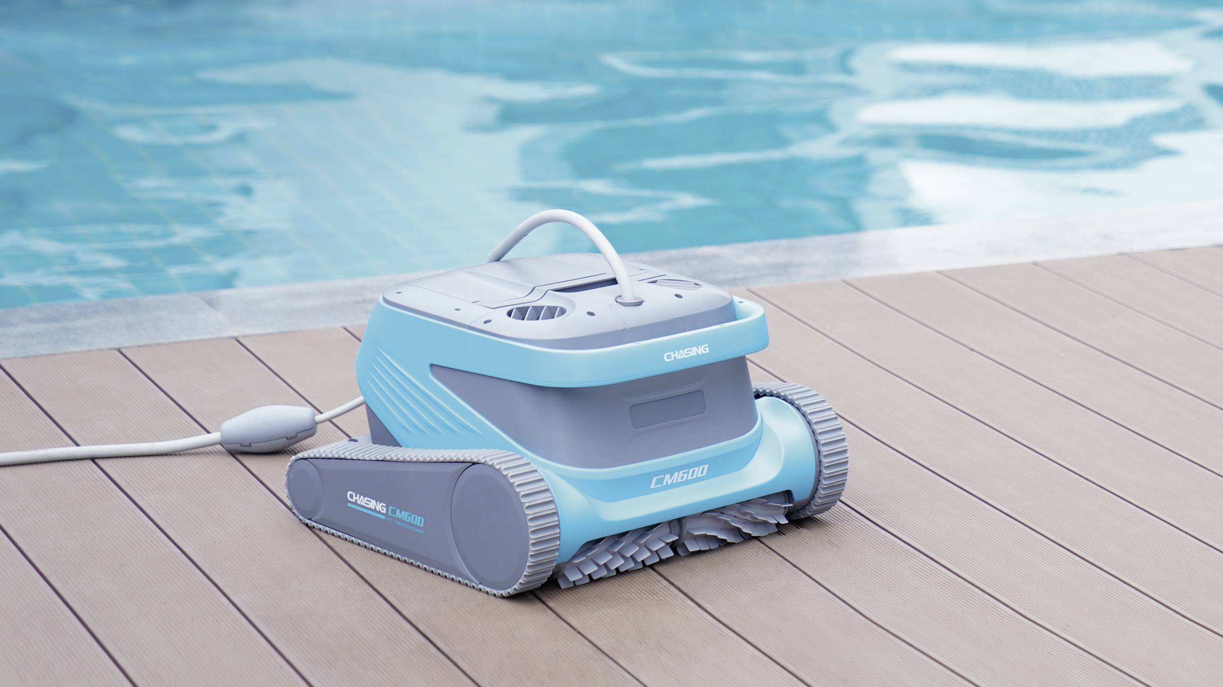 Ein blauer Poolreinigungsroboter auf Holzdeck am Beckenrand eines Schwimmbeckens, bereit zur Reinigung.