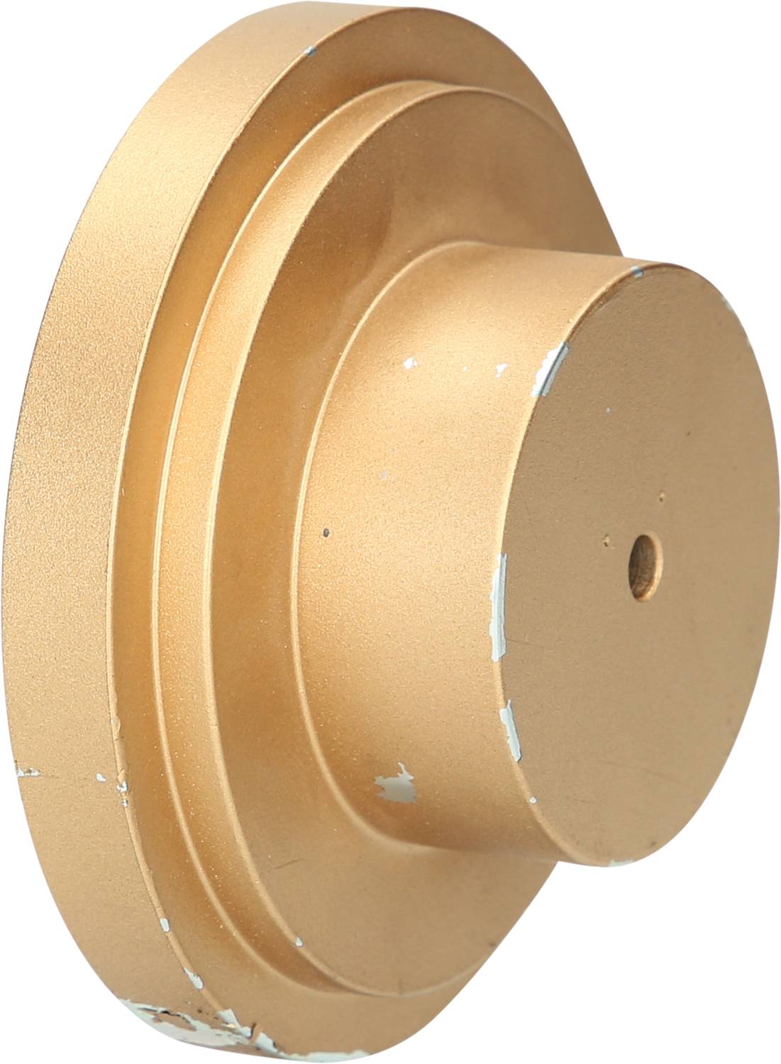 Goldene, runde, gestufte Metallstruktur mit Kratzern.