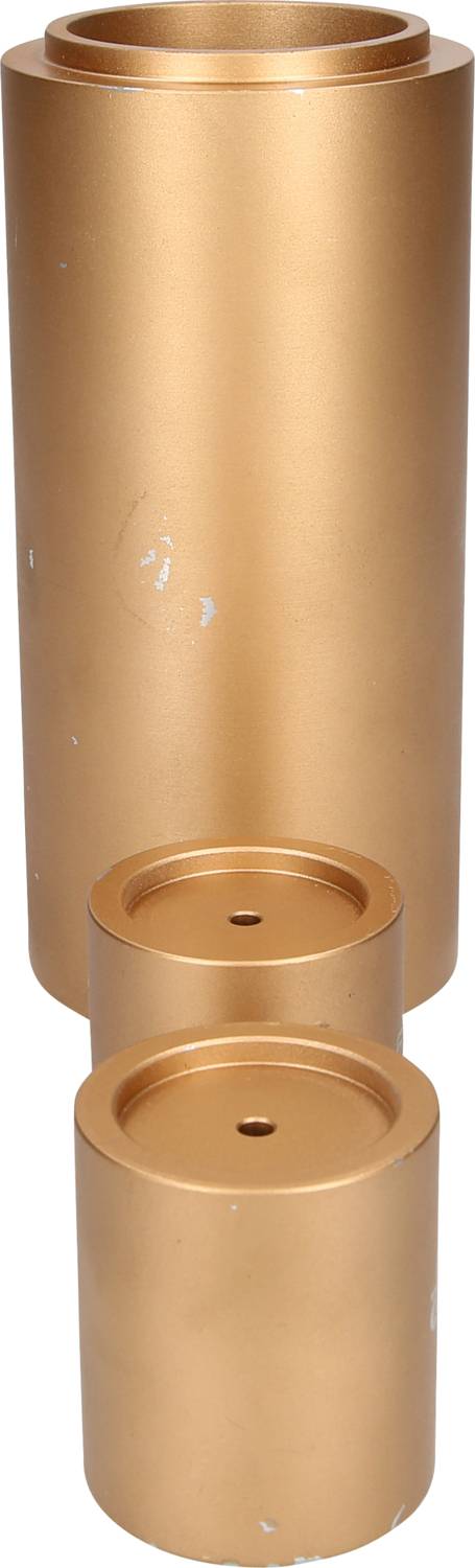 Zwei kleinere und ein größerer goldfarbener Metallzylinder stehen aufrecht auf einer weißen Oberfläche.
