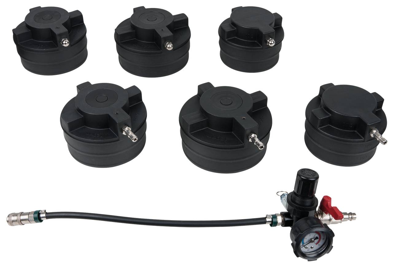 Verschiedene schwarze Prüfdeckel und ein Druckregler mit Manometer für Tests in der Fahrzeugtechnik.