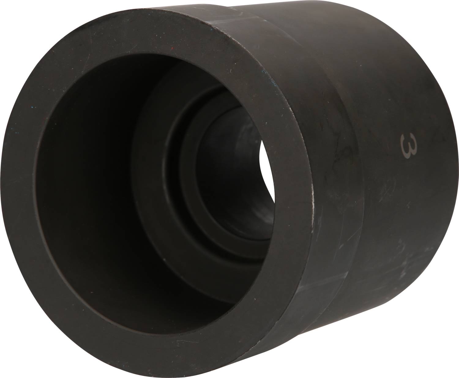 Ein großes, schwarzes zylindrisches Objekt mit einem zentralen Loch, das wie ein technisches Bauteil aussieht, in einer neutralen Umgebung.