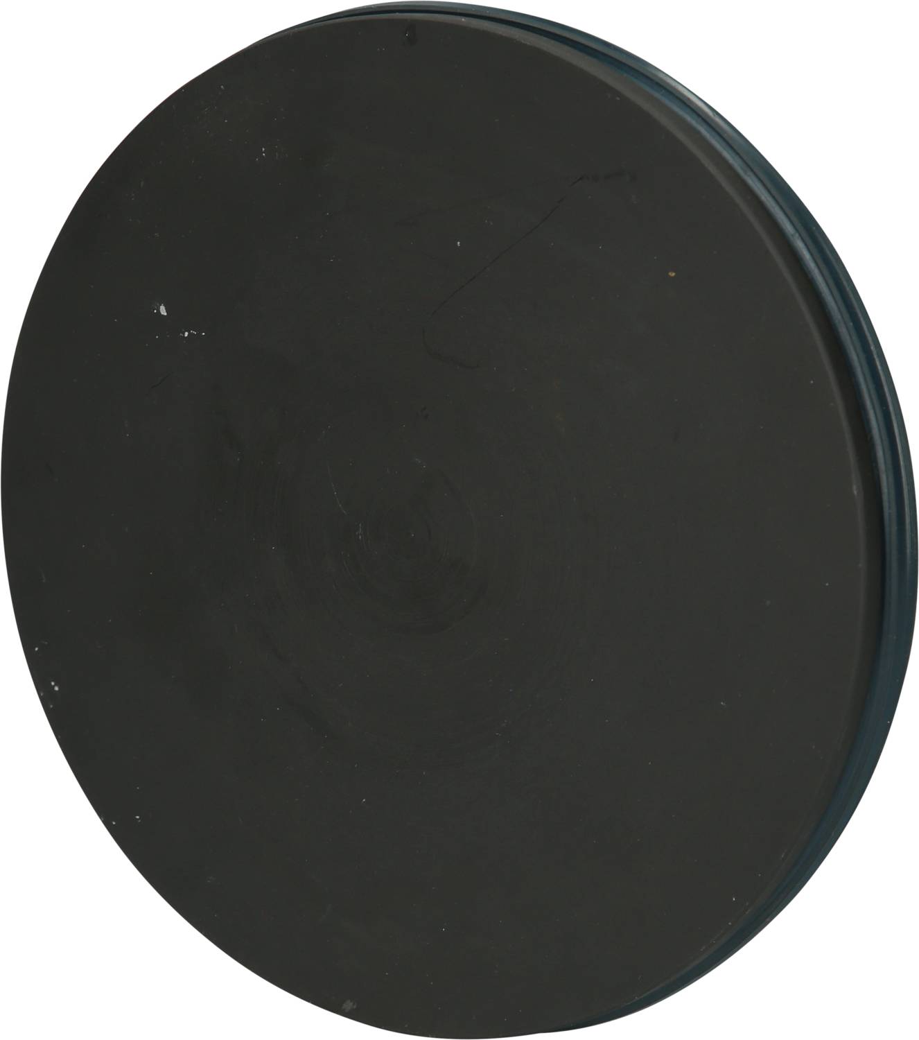 Schwarze, runde Gummischeibe, flach und glatt, vor weißem Hintergrund.
