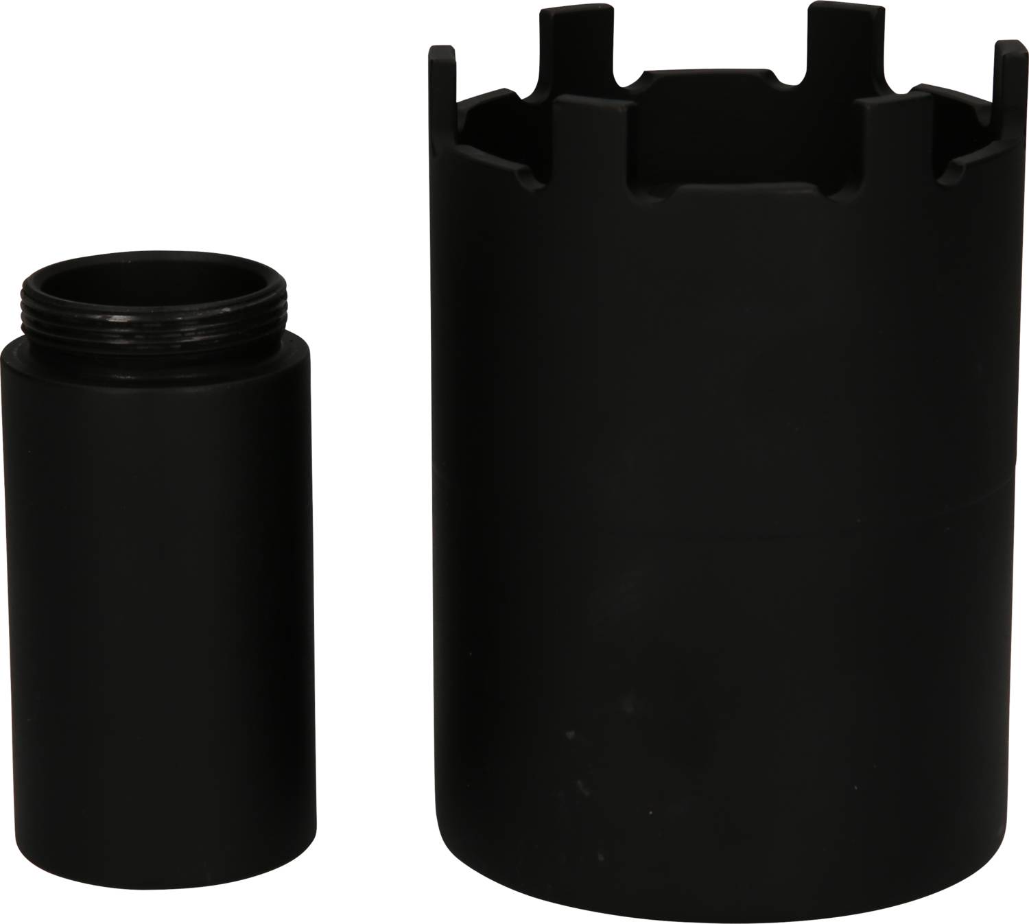 Schwarze, zylindrische Bauteile aus Metall, eines mit mehreren Aussparungen am Rand. Sie sind nebeneinander positioniert.