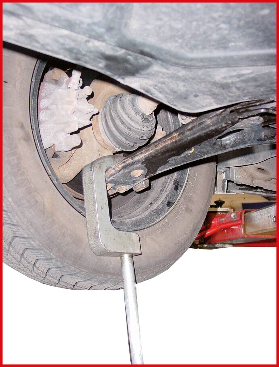 Straßenfahrzeug-Reparatur: Ein Metallwerkzeug stützt die Radaufhängung eines Autos, während es angehoben wird.
