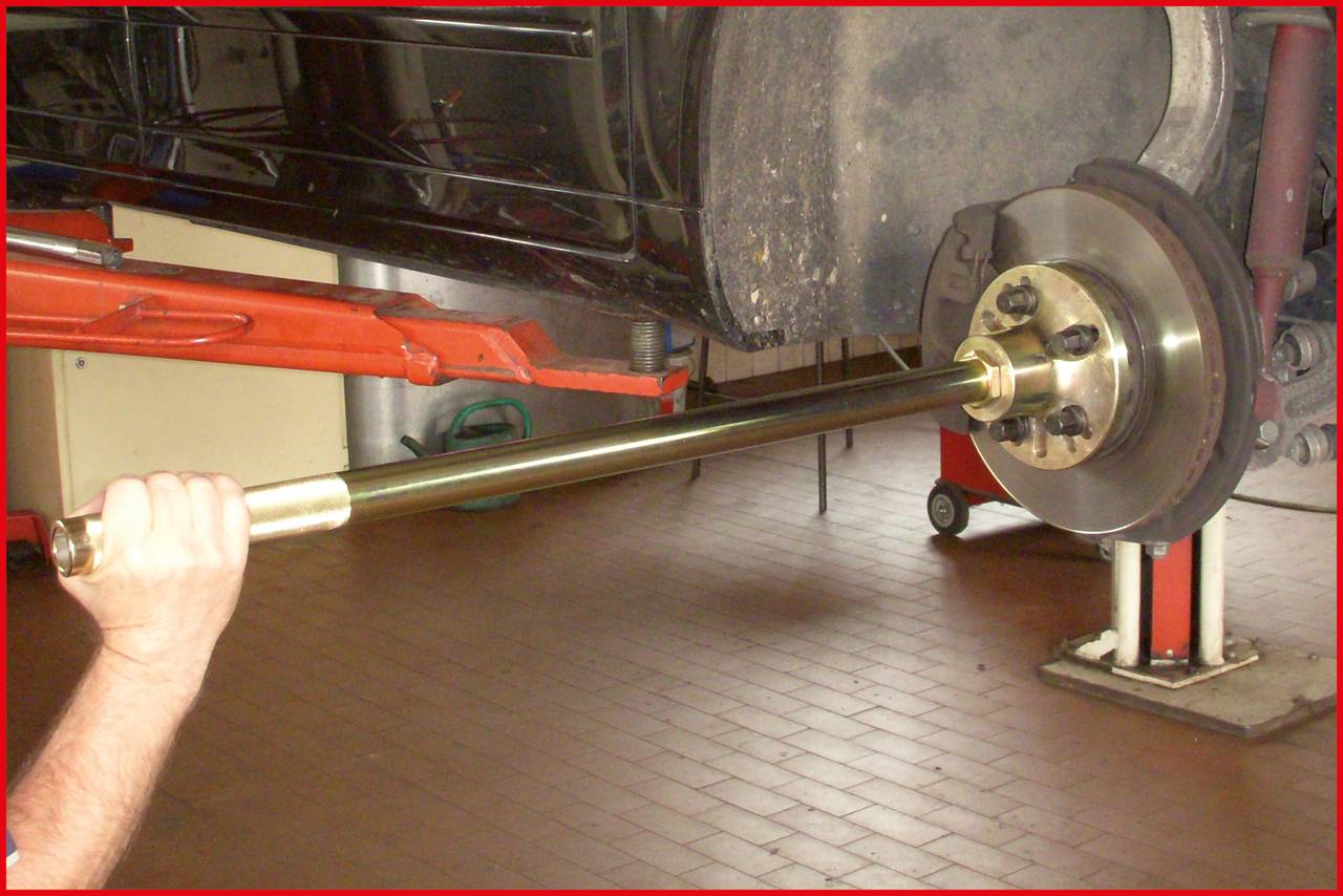 Eine Person verwendet ein Werkzeug zur Auswuchtung oder Reparatur einer Bremsscheibe in einer Autowerkstatt.