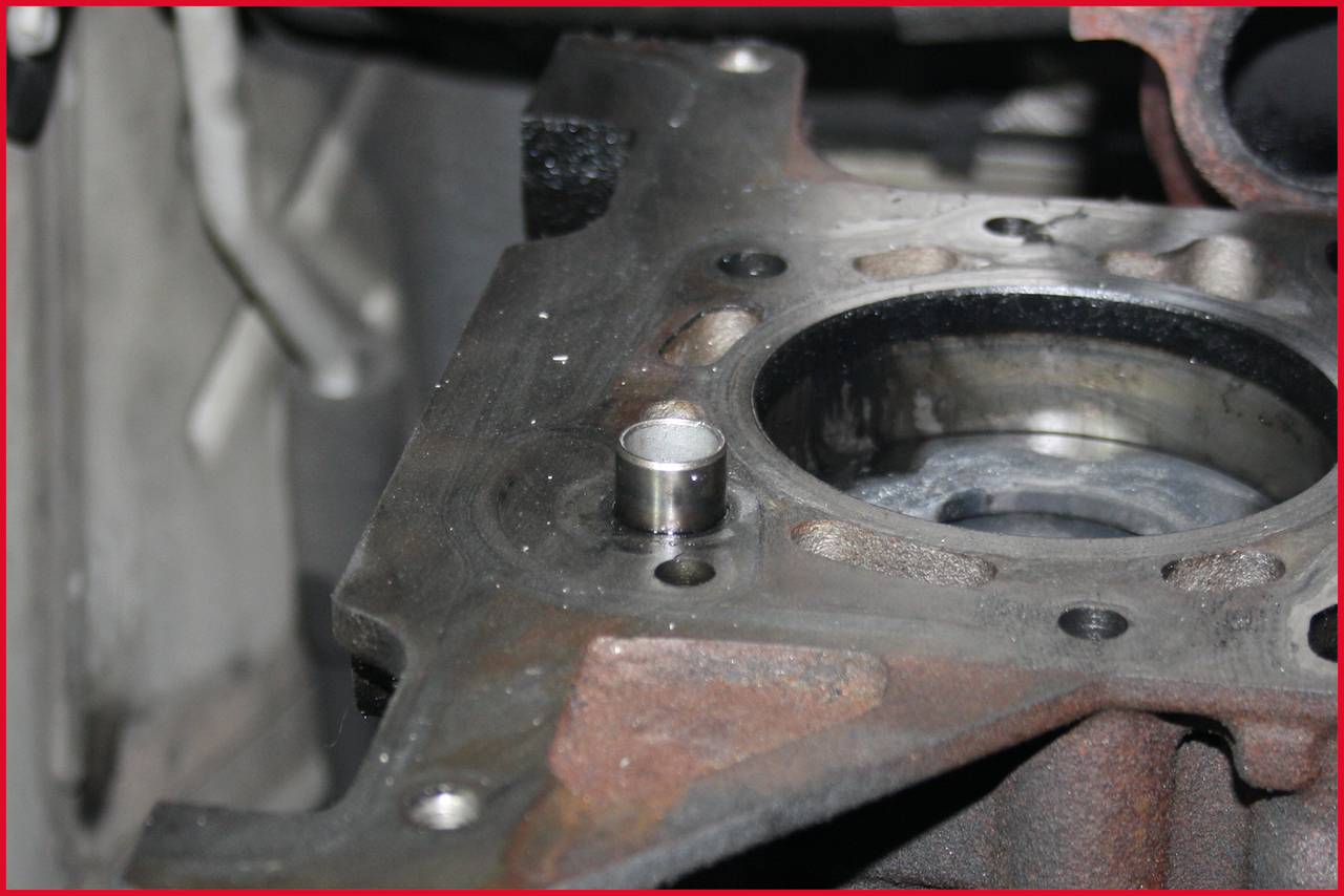 Metallischer Zylinderkopf mit Ventilsitz und Schraubenbohrungen. Deutliche Gebrauchsspuren sichtbar.