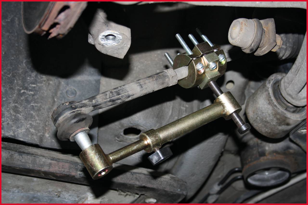 Untere Ansicht eines Fahrwerks mit montierten Spurstangen und Muttern. Enthält Metallkomponenten, die für die Lenkung wichtig sind.
