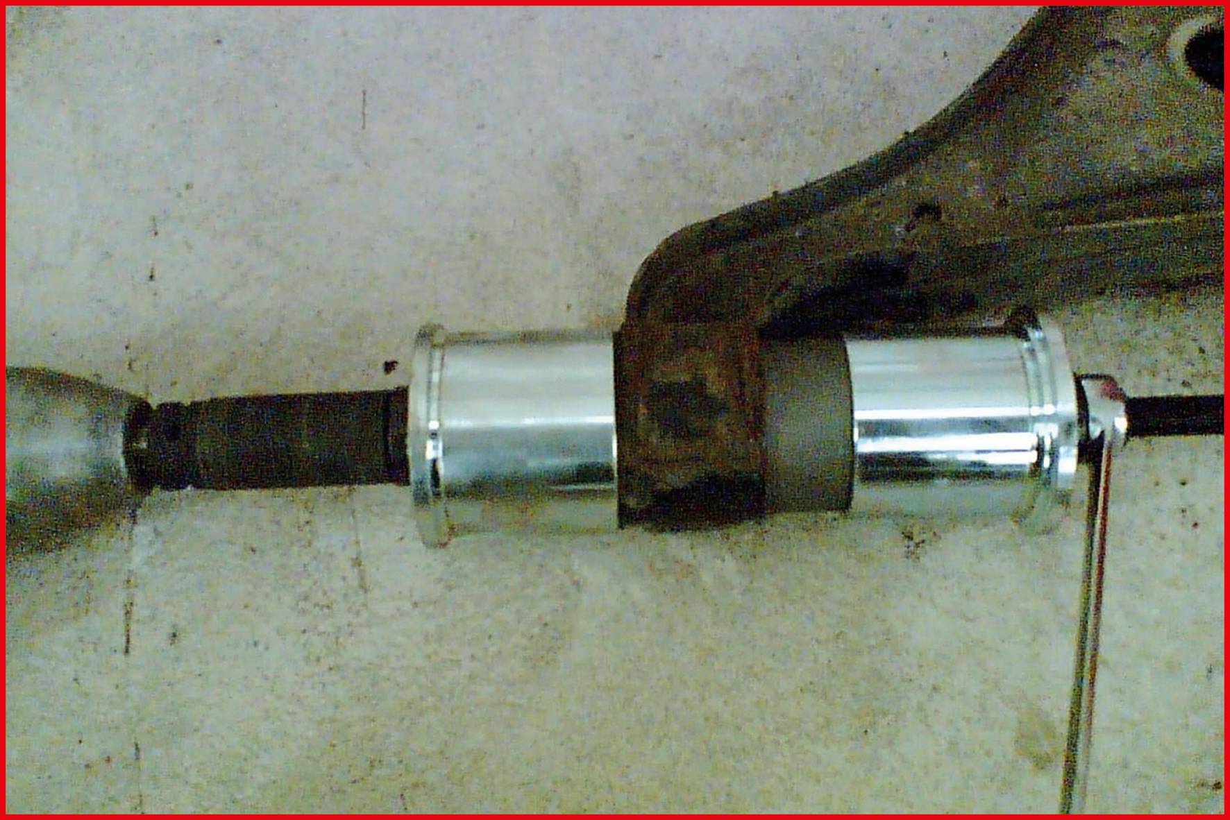 Nahaufnahme eines Autoteils, möglicherweise ein mechanisches Verbindungselement, auf einer Werkbank liegend.