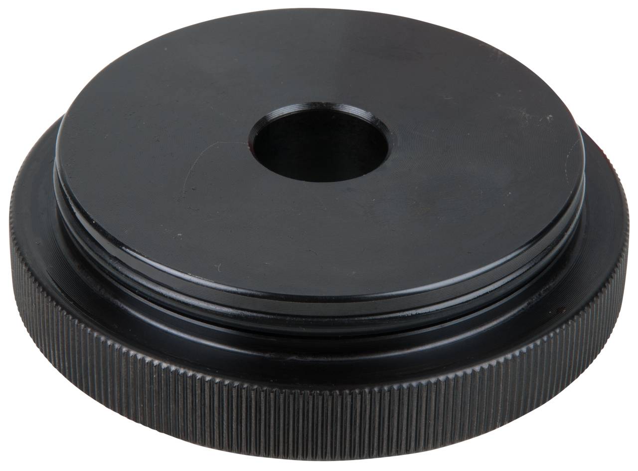 Schwarze, runde Abdeckkappe mit mittigem Loch, geriffeltem Rand und glatter Oberfläche, möglicherweise für mechanische Zwecke.