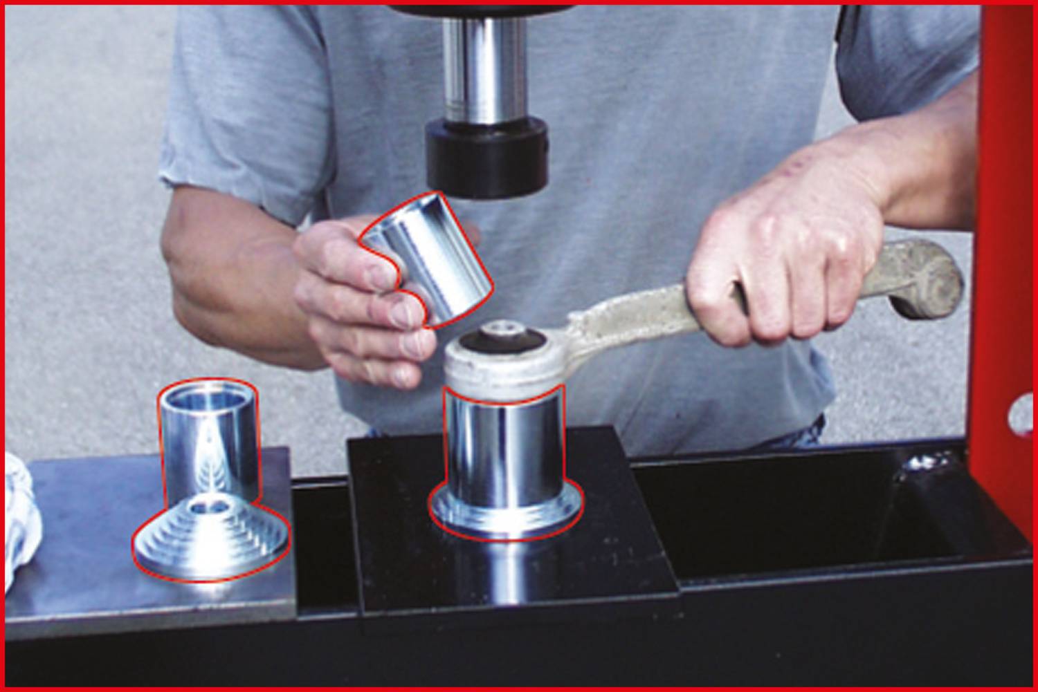 Eine Person führt ein mechanisches Umformverfahren durch, um Metallteile mit einer Maschine zu biegen. Links liegen fertige Metallteile.