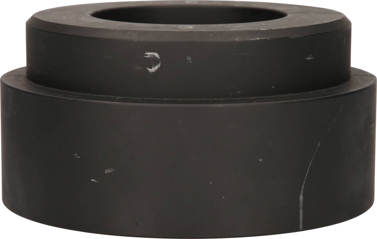 Ein schwarzes, zylindrisches Objekt mit zwei abgestuften Abschnitten. Es scheint ein technisches oder mechanisches Bauteil zu sein.