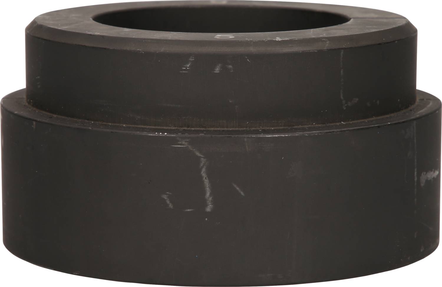 Ein schwarzer, zylindrischer Metallblock mit zwei übereinanderliegenden Stufen, ohne sichtbare Markierungen oder Beschriftungen.