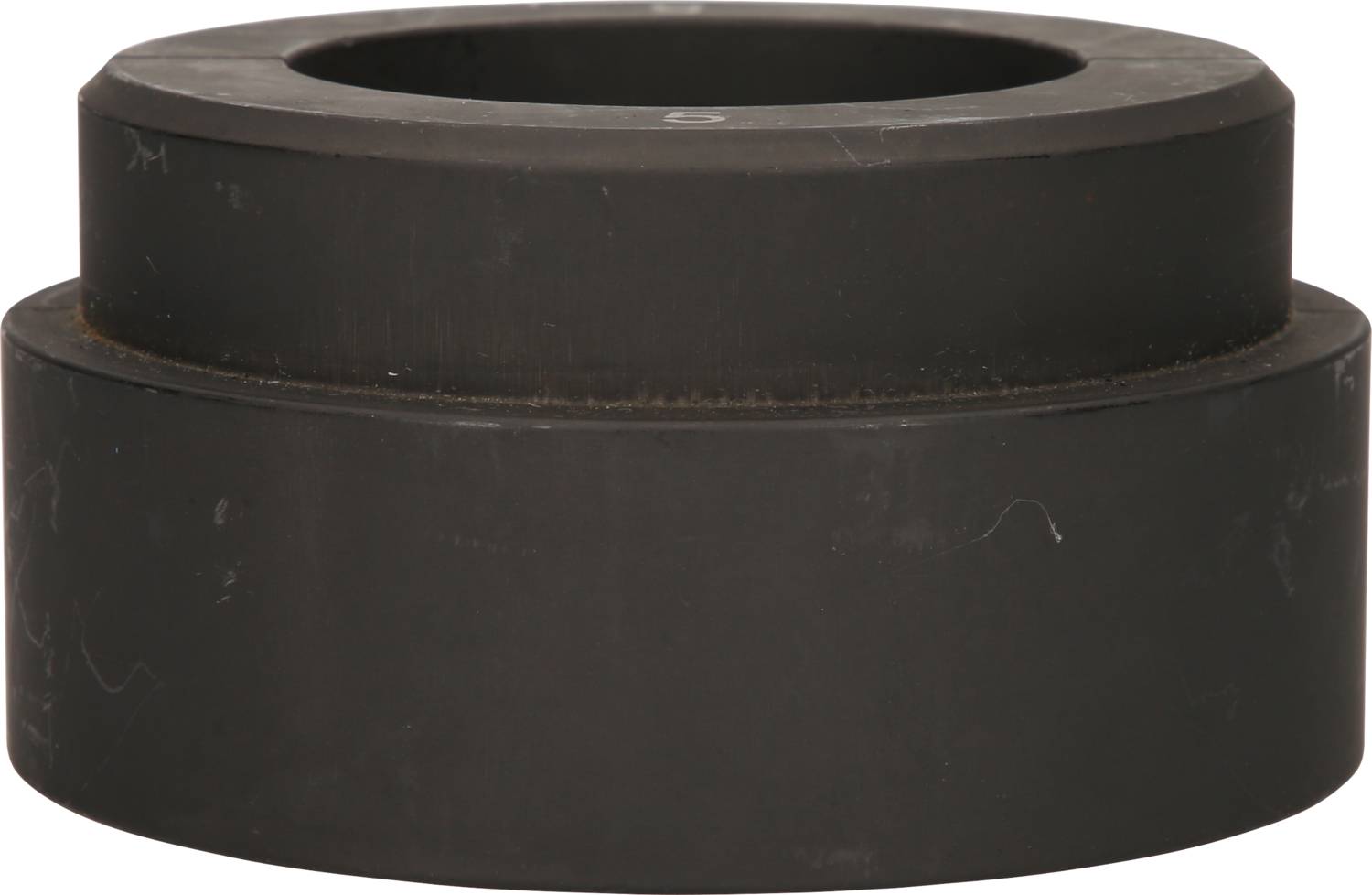 Ein schwarzer, zylindrischer Ring aus Metall, flach und massiv, liegt auf einem weißen Hintergrund.