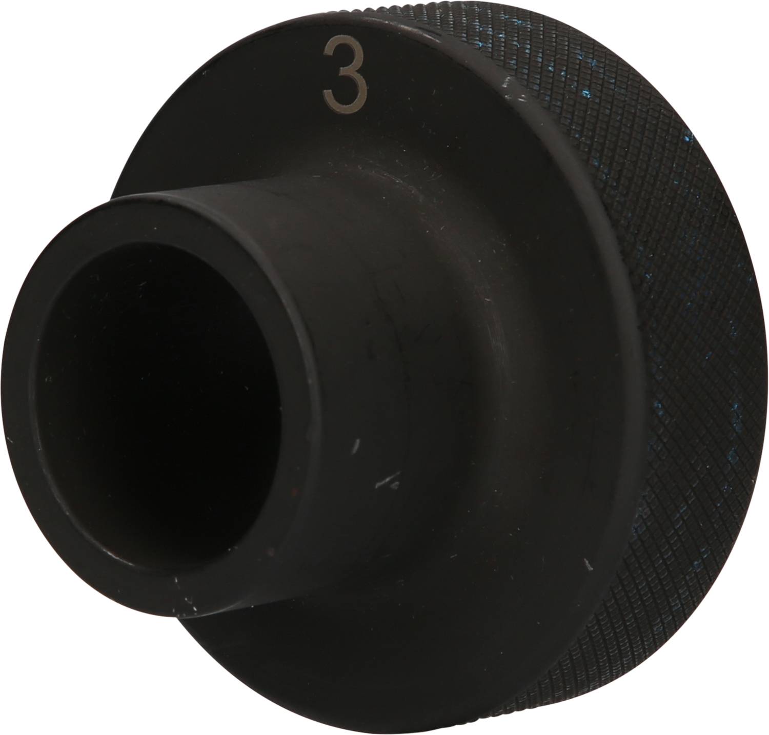 Ein schwarzes, kreisförmiges Metallteil mit der Nummer '3' darauf. Es hat eine zentrale Öffnung und eine gerändelte Oberfläche.