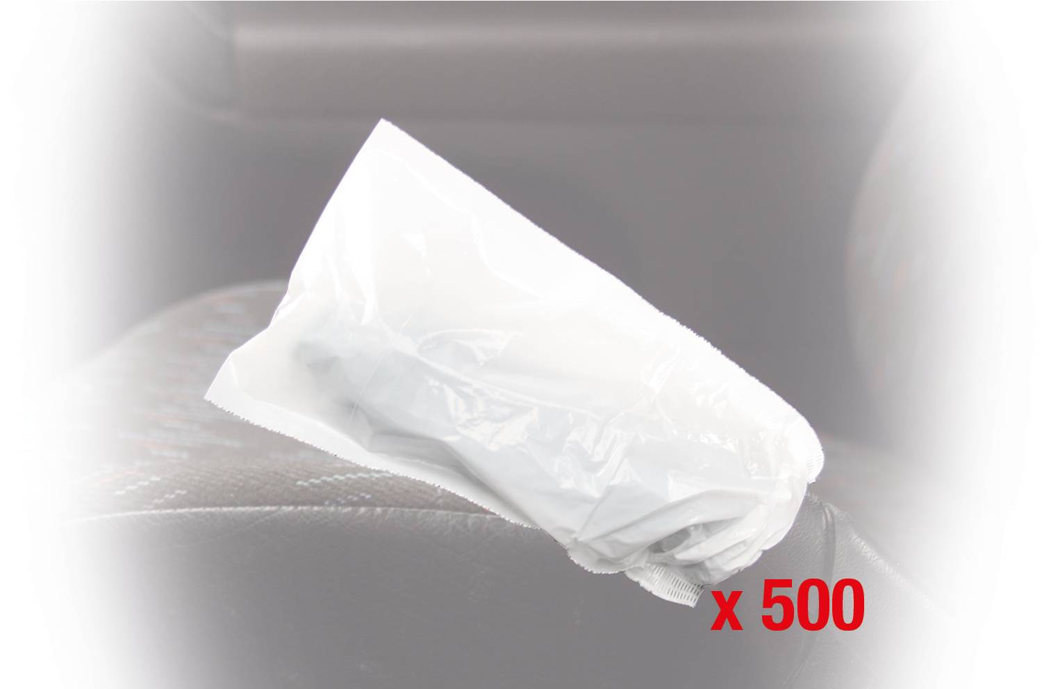 Eine in Plastik verpackte Einwegspritze liegt auf einem Autositz. In roter Schrift steht 'x 500', was auf eine Menge hinweist.