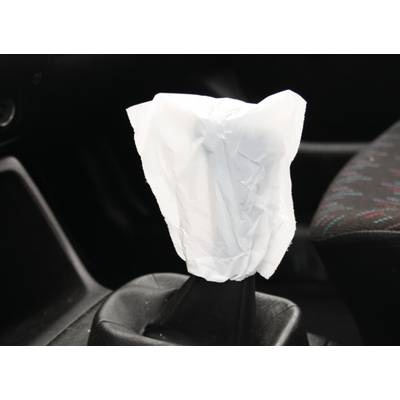 Ein Schalthebel in einem Auto ist mit einer weißem Plastikfolie umhüllt.