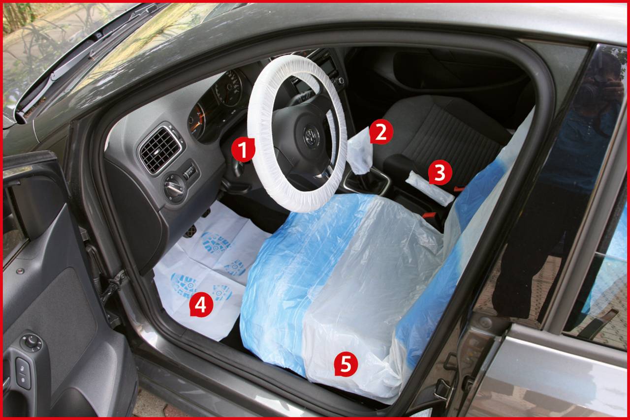 'Auto-Innenraum mit Schutzfolien auf Lenkrad und Sitzen', nummerierte Elemente weisen auf bestimmte Bereiche im vorderen Teil hin.