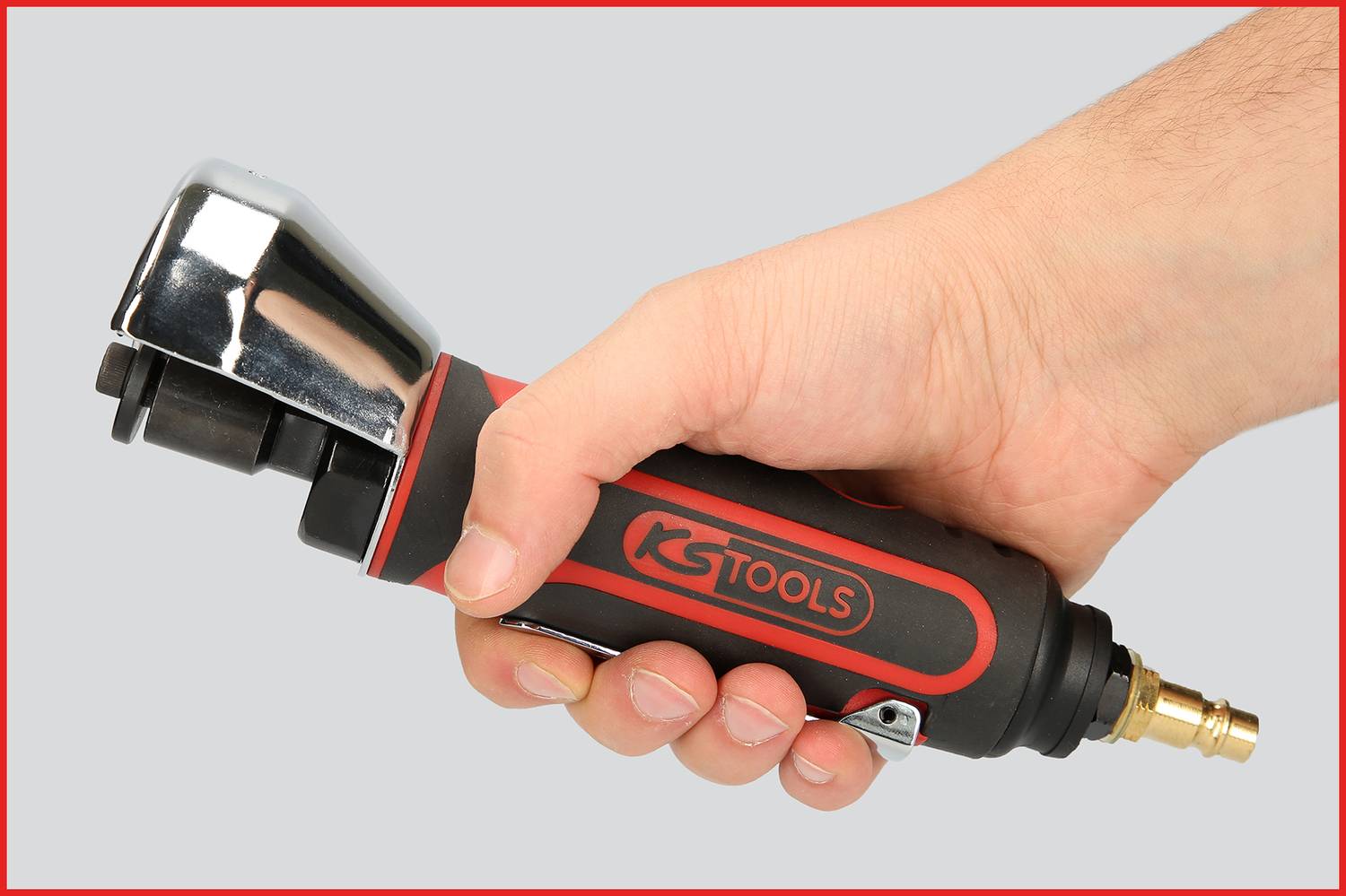 Eine Hand hält ein Druckluftwerkzeug von 'KS Tools' mit schwarzem und rotem Griff. Das Werkzeug hat ein metallisches Ende.
