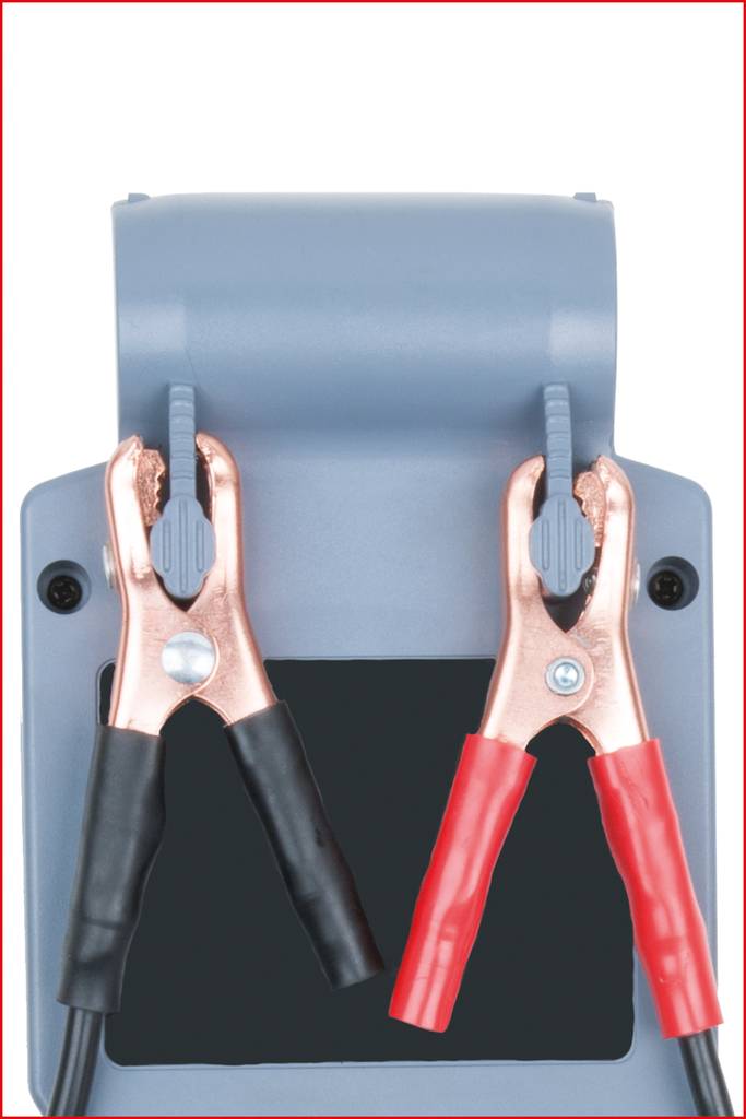 Ein graues Gerät mit zwei Klammern: links eine schwarze negative Klemme, rechts eine rote positive Klemme. Sie halten Kabel.