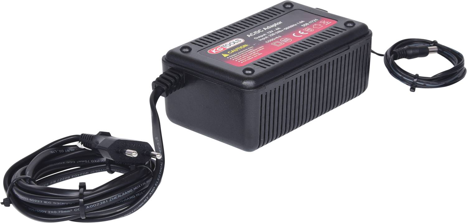 Ein schwarzes, rechteckiges Batterieladegerät mit Kabeln, die aus beiden Enden herausragen. Ein Etikett auf der Oberseite zeigt technische Details.