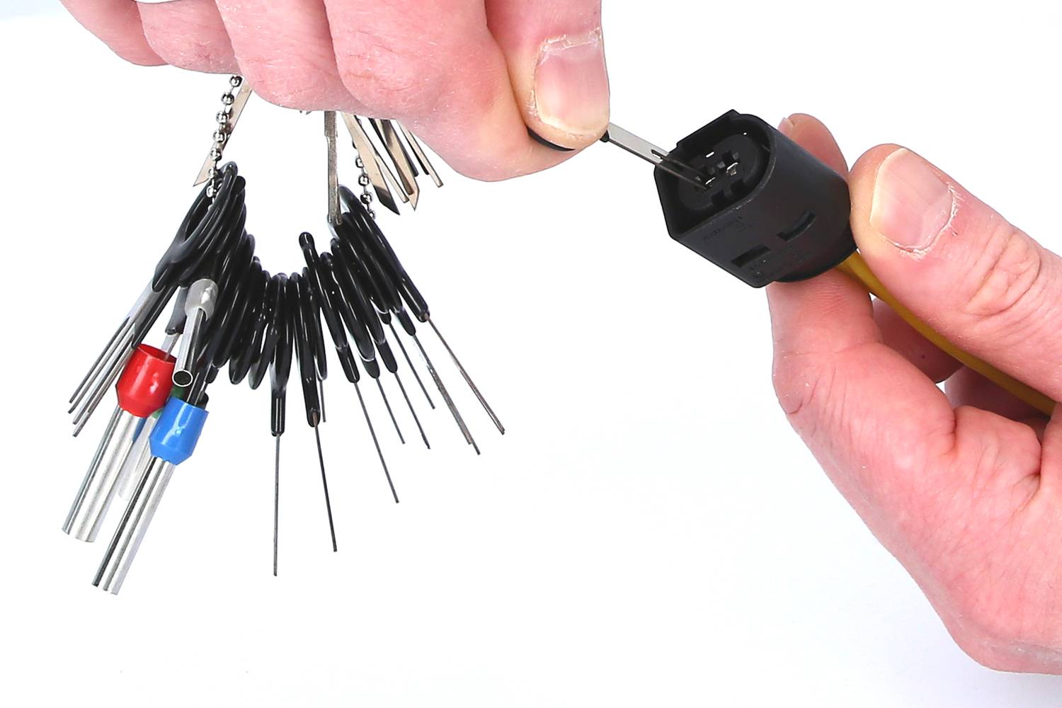 Zwei Hände halten einen Autoschlüssel-Entriegelungswerkzeug-Satz und verwenden ihn, um einen Autoschlüssel zu demontieren.