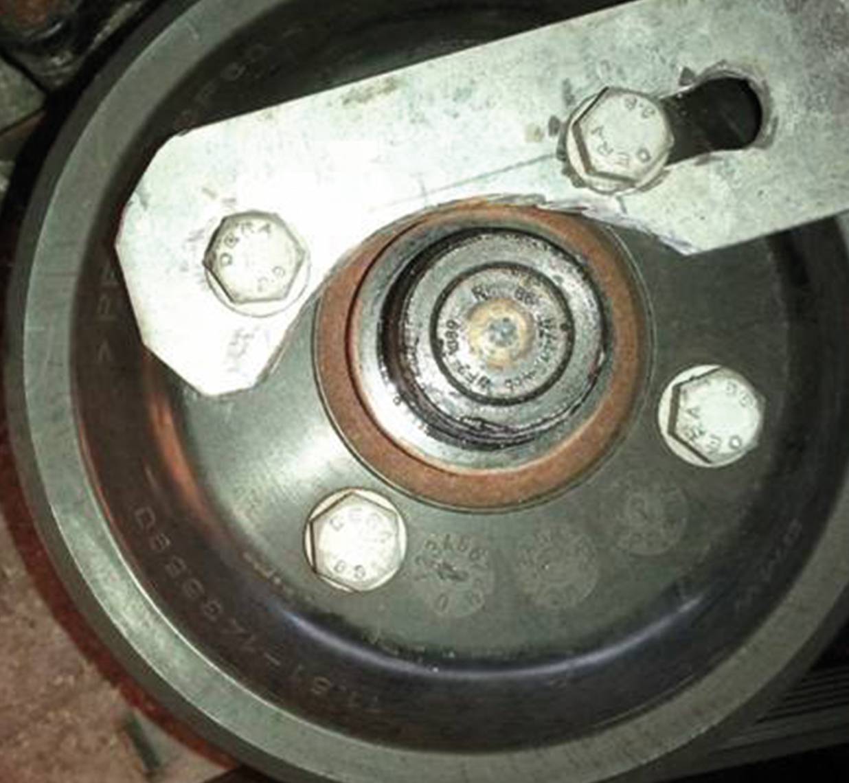 Eine Maschine mit einem Metallrad und Schrauben. Der Fokus liegt auf der technischen Bauweise und den sichtbaren Bolzen auf dem Rad.